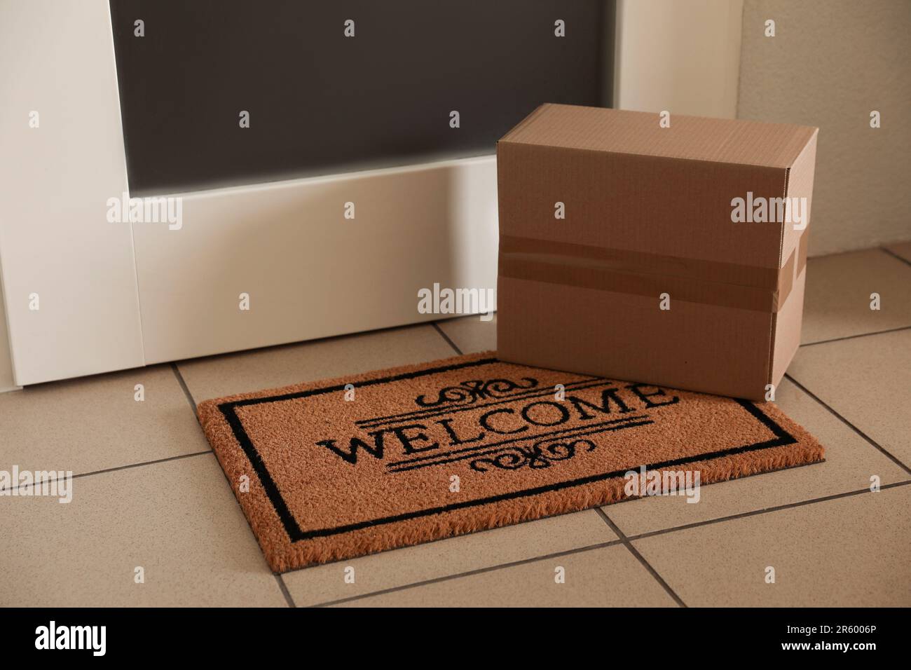 Parcel delivered on mat near front door Stock Photo