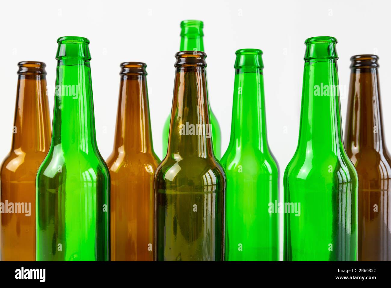 Empty glass beer bottles, brown in color, arranged side by side and