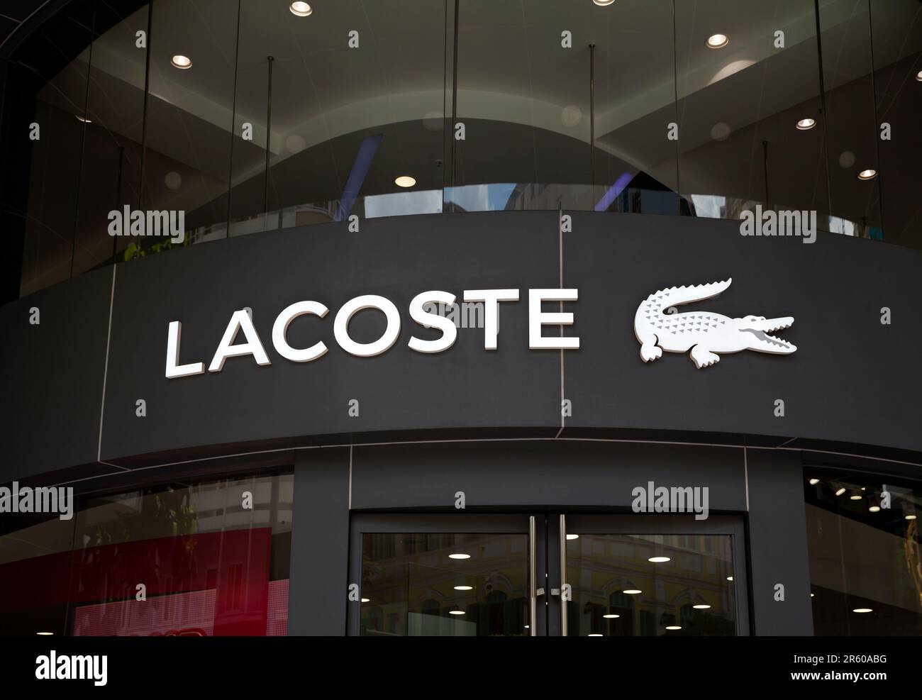 Ho Chi Minh City, Vietnam - June 4, 2023: Fashion store commercial sign with black and white Lacoste logo. Famous luxury fashion brand logotype above Stock Photo