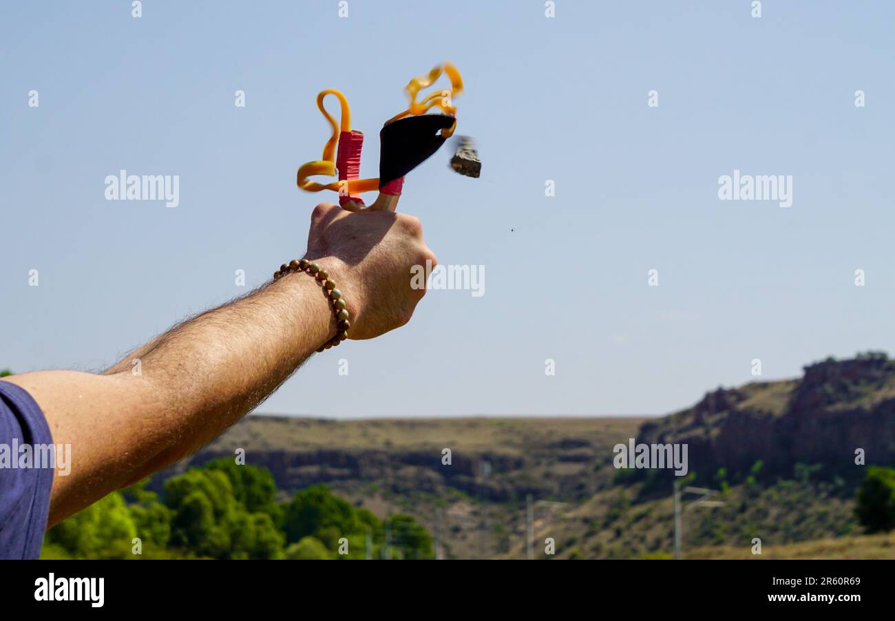 Man using spear thrower throwing rock nature amusement Stock Photo Alamy