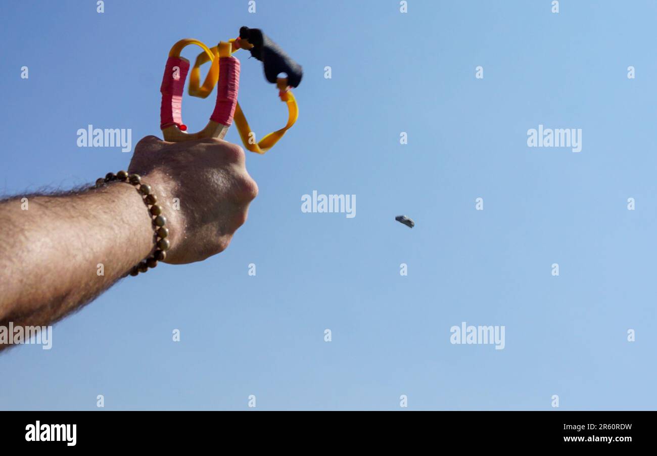 Man using spear thrower throwing rock nature amusement Stock Photo - Alamy