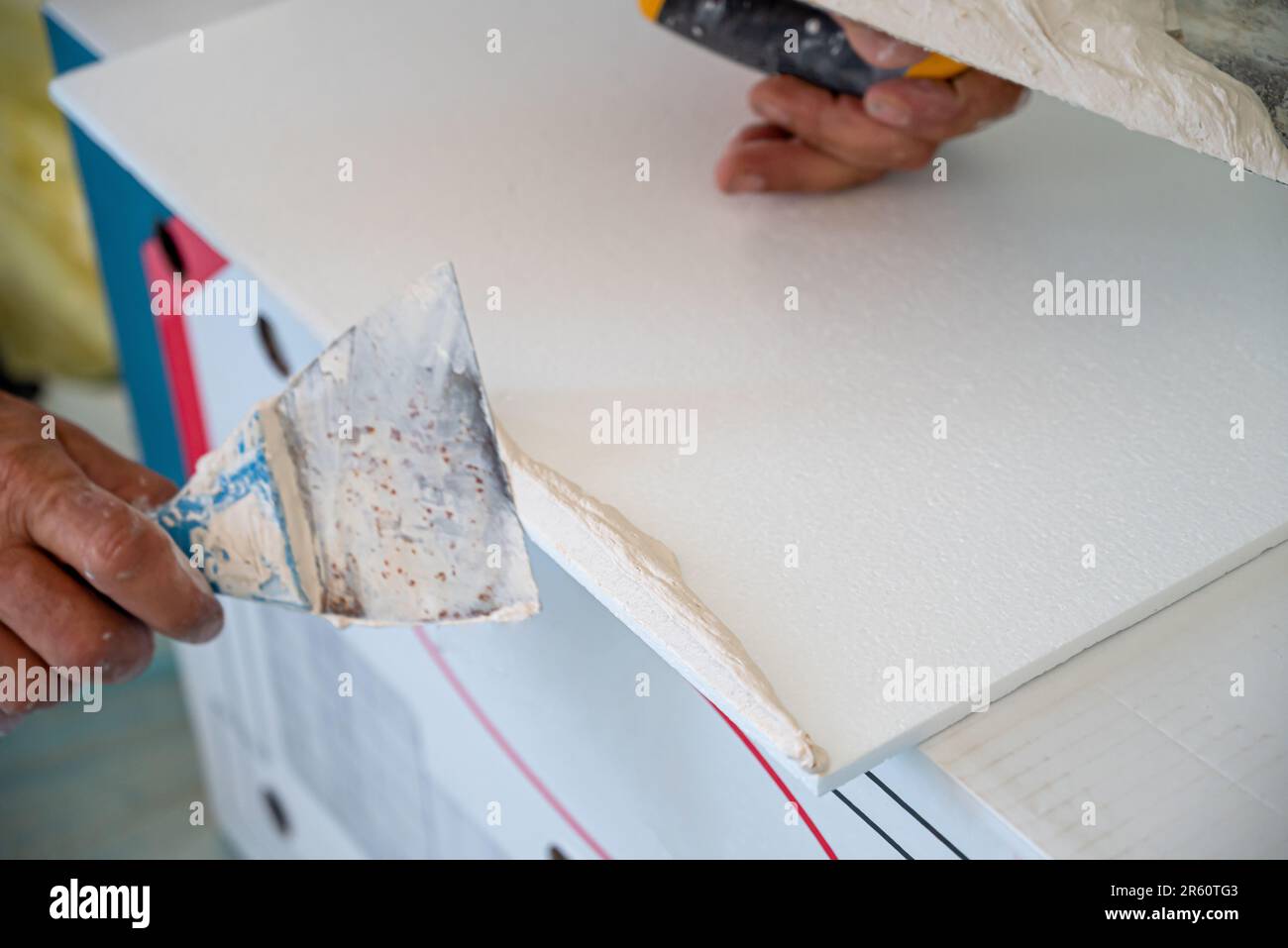 adhesive plaster application of styrofoam ceiling tiles of a home kitchen Stock Photo