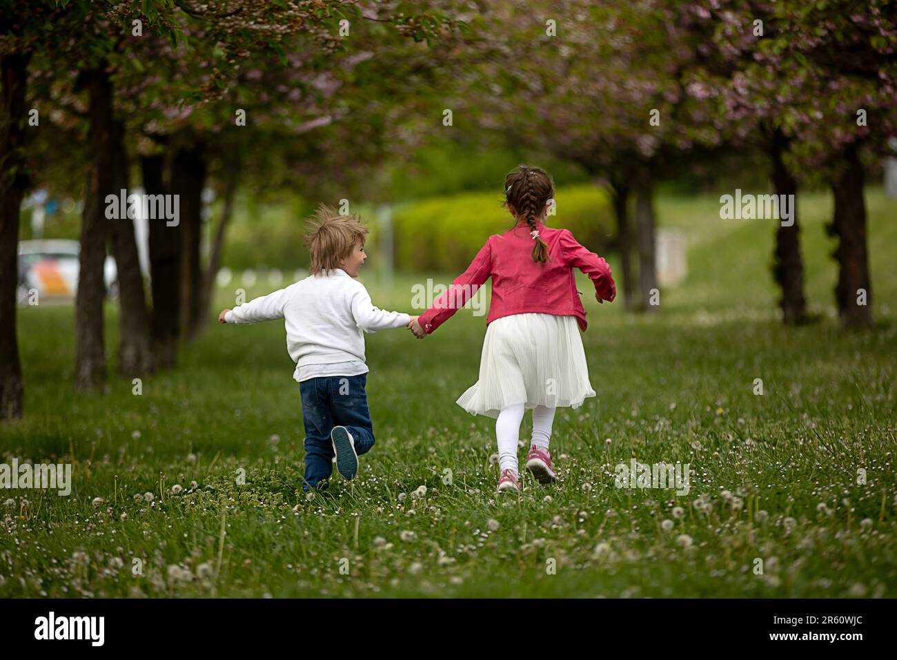 Beautiful preschool children, boy and girl, running in the park with ...