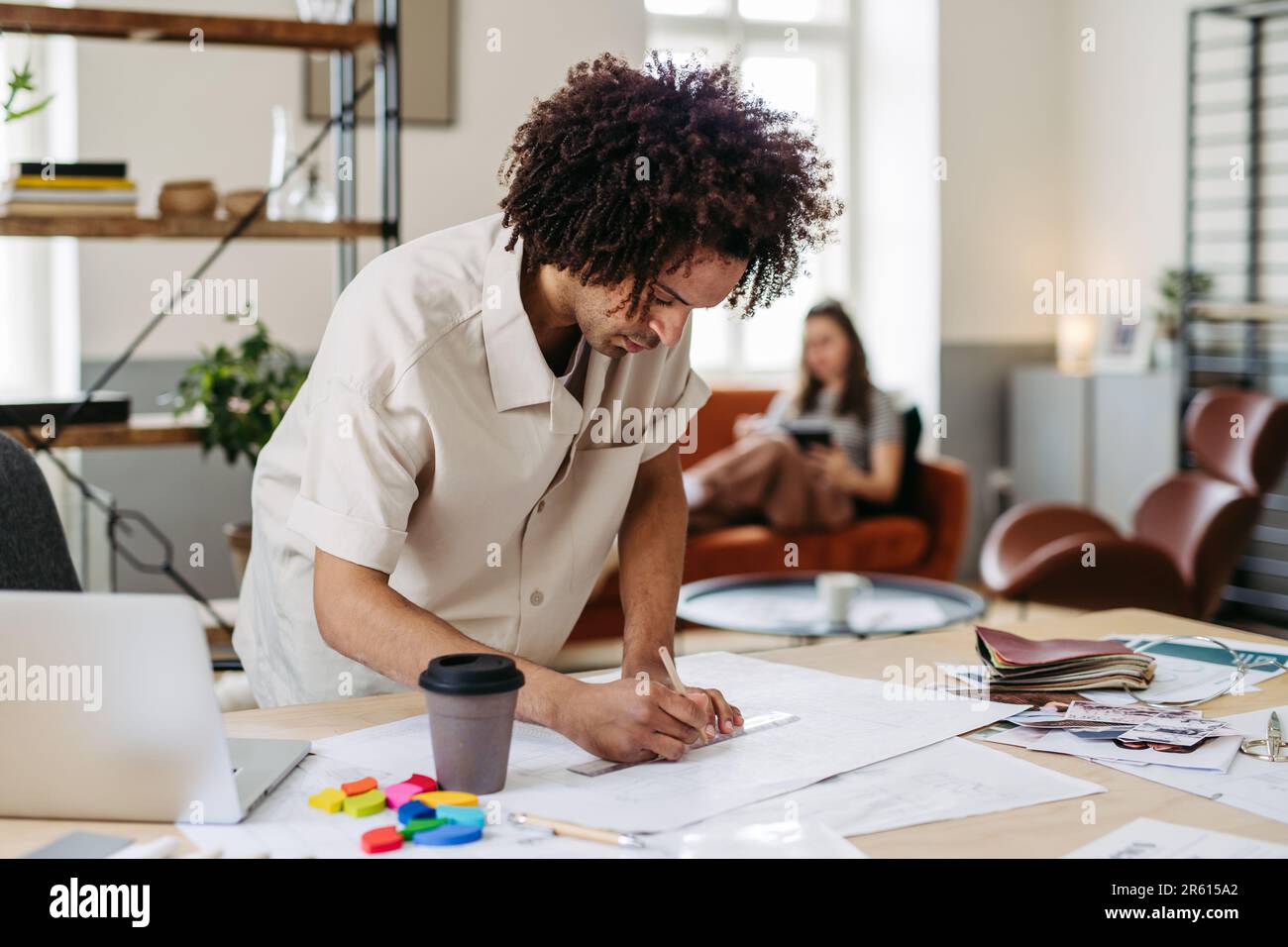 Young multiracial man drawing something in designers studio. Stock Photo