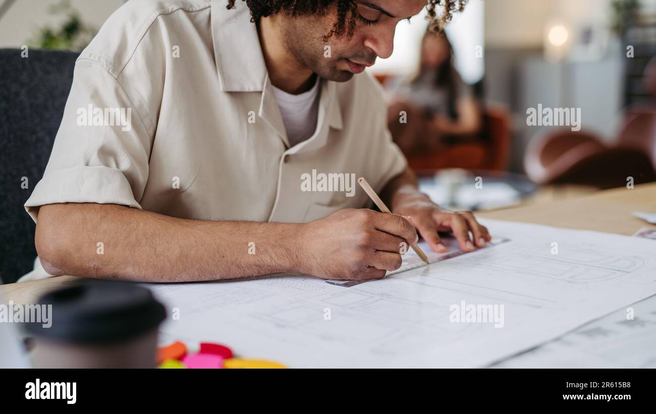 Young multiracial man drawing something in designers studio. Stock Photo