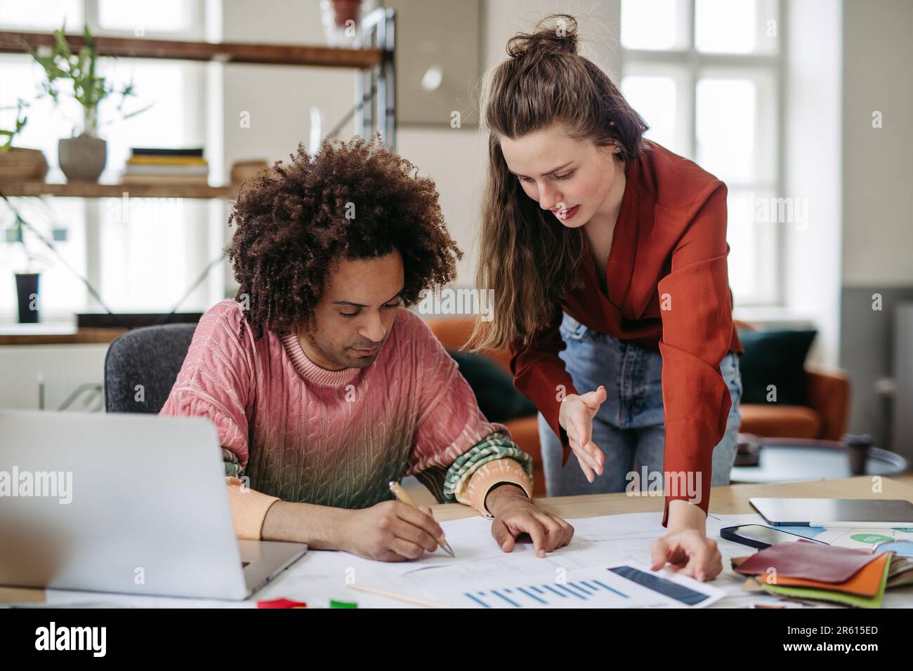 Young colleagues working together in startup company. Stock Photo