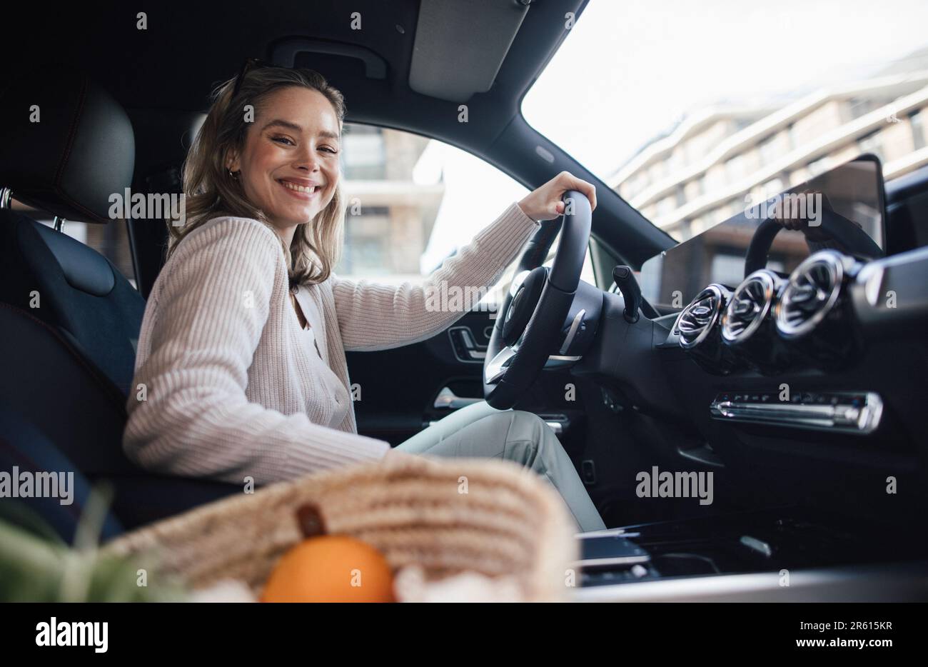 Happy woman driving her new electric car. Stock Photo
