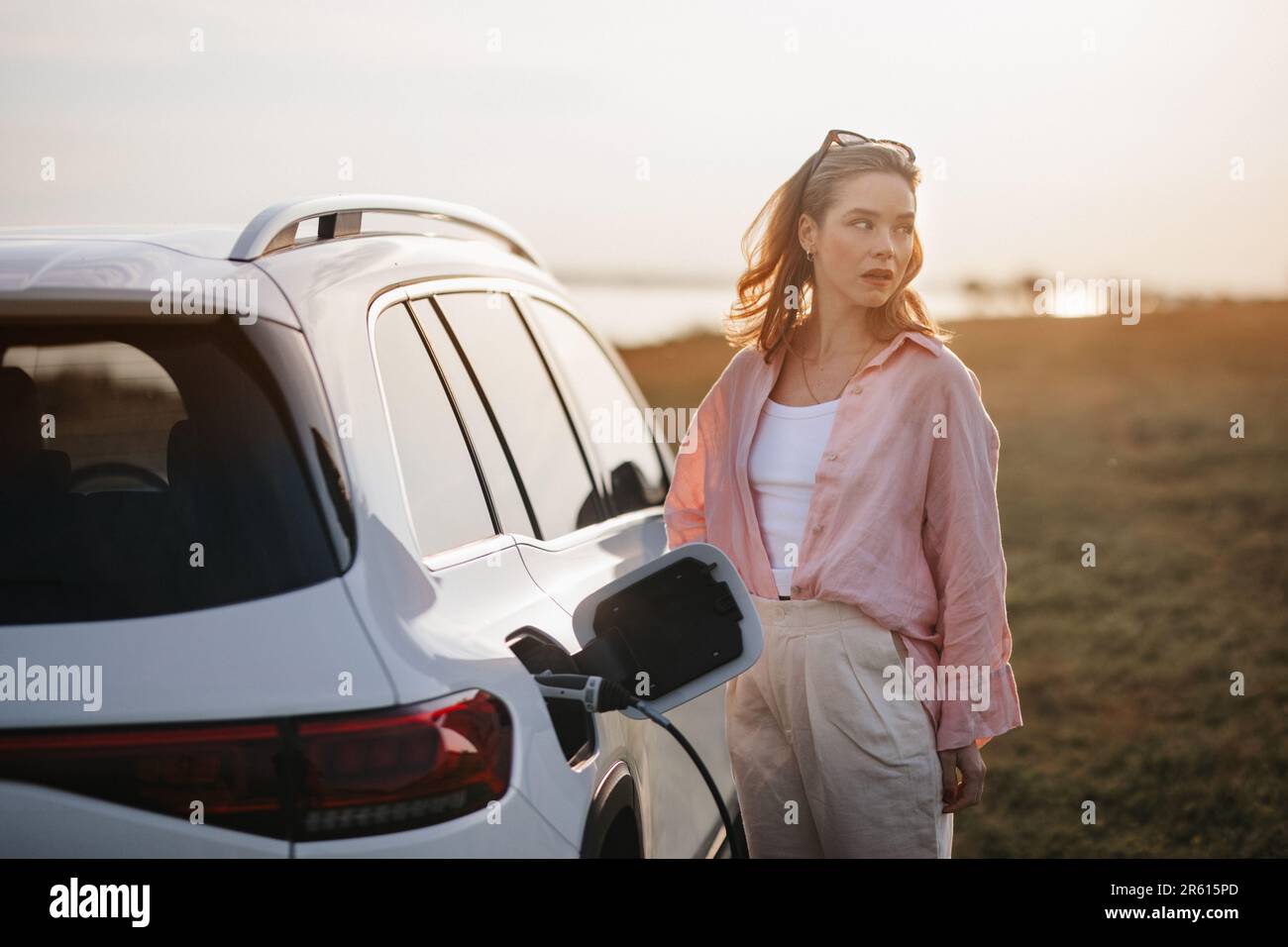 Woman charging her electric car, prepared for charging it sustainable and economic transportation concept. Stock Photo