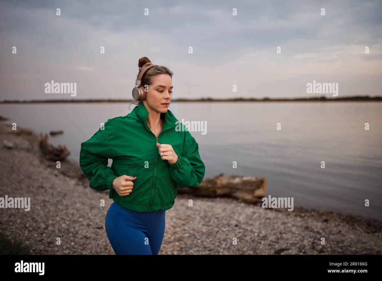 Young woman runing outdoor, near the lake. Stock Photo