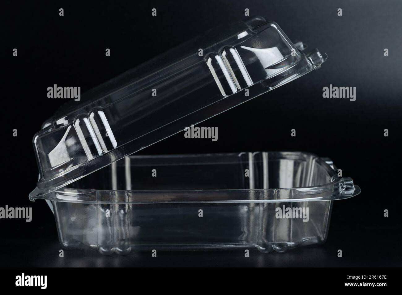 Open plastic food square box side view isolated on black studio background Stock Photo