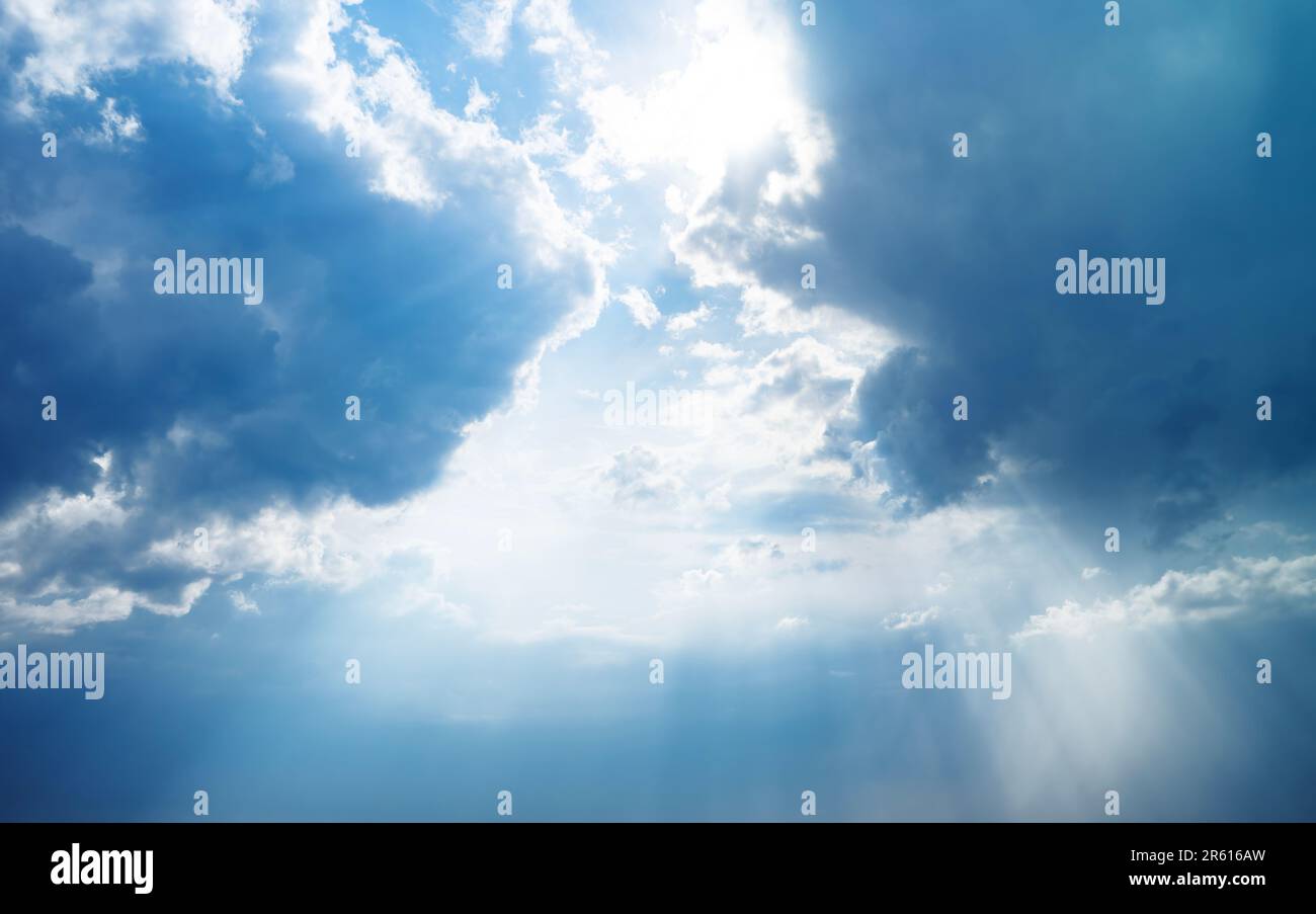 Blue dramatic sky background with clouds and sun rays coming out Stock ...