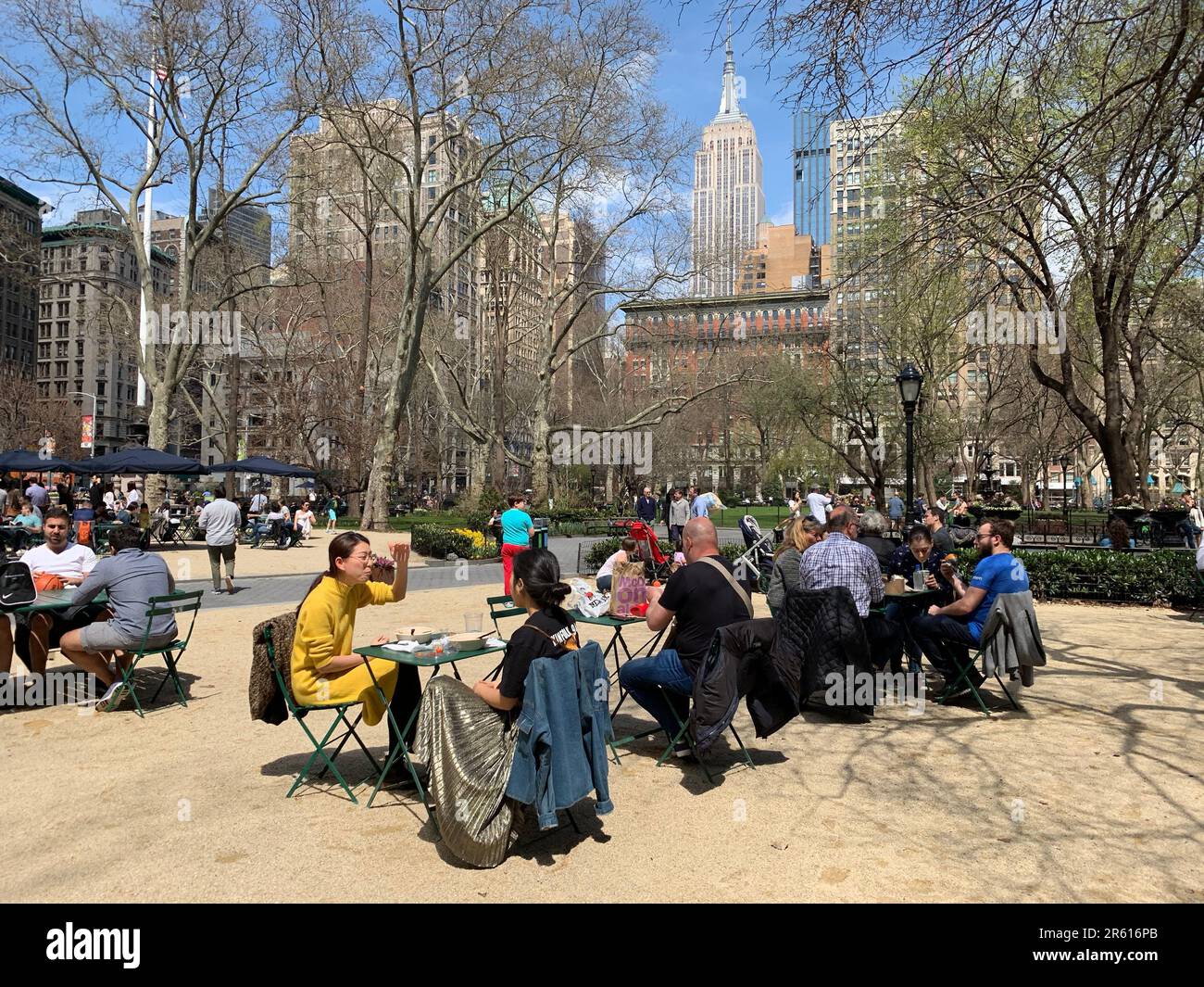 People enjoy a warm and sunny spring day at an al fresco cafe in New York City Stock Photo