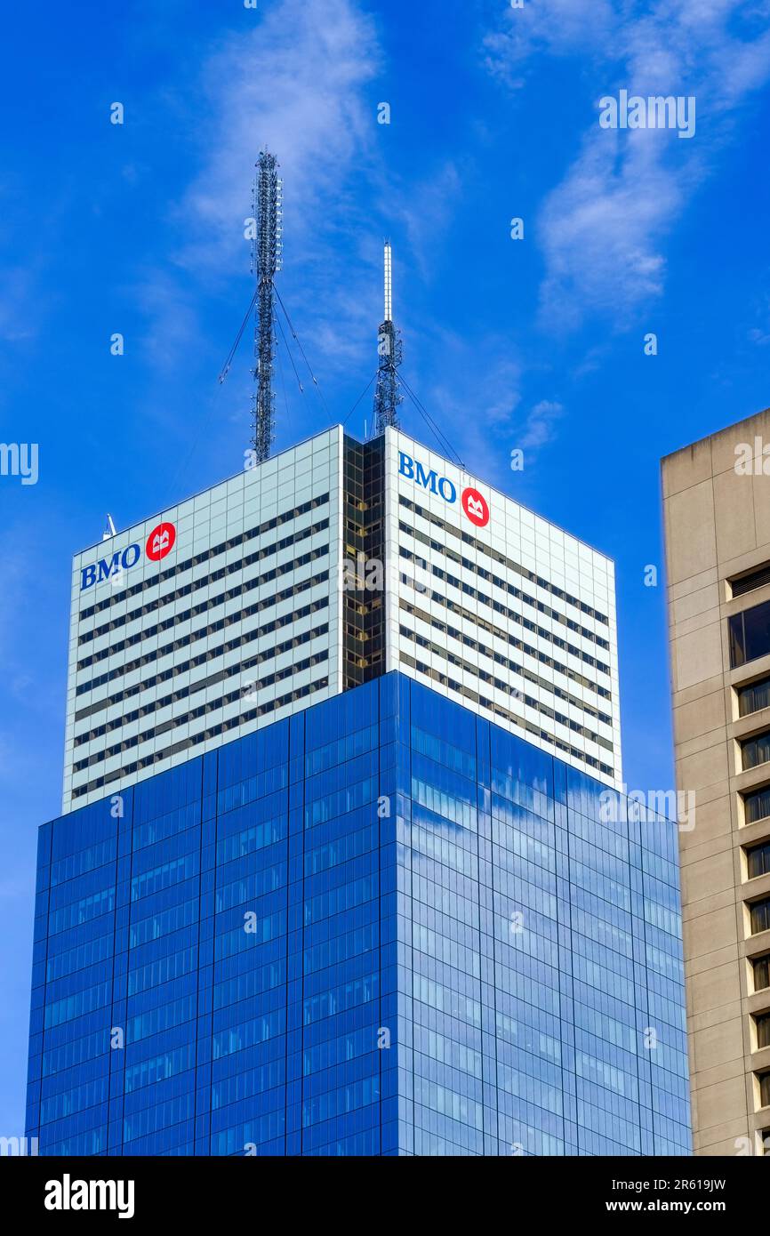Toronto, Canada - May 13, 2023: The upper section of a tall blue building with a glass exterior, featuring a prominent billboard displaying the letter Stock Photo