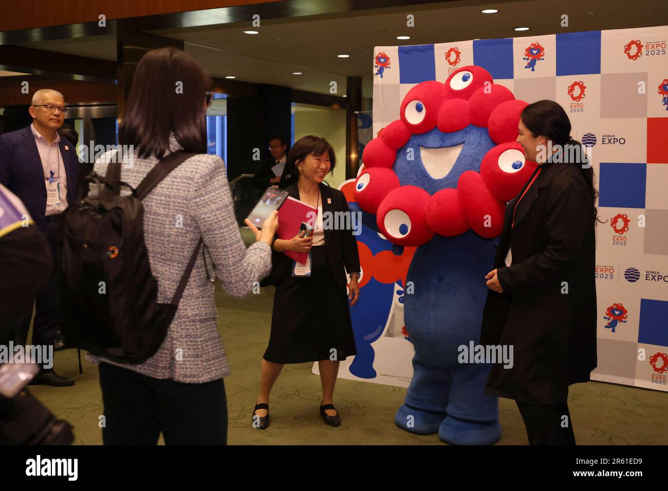 Guests pose with MyakuMyaku, a mascot of the 2025 World Expo in Osaka