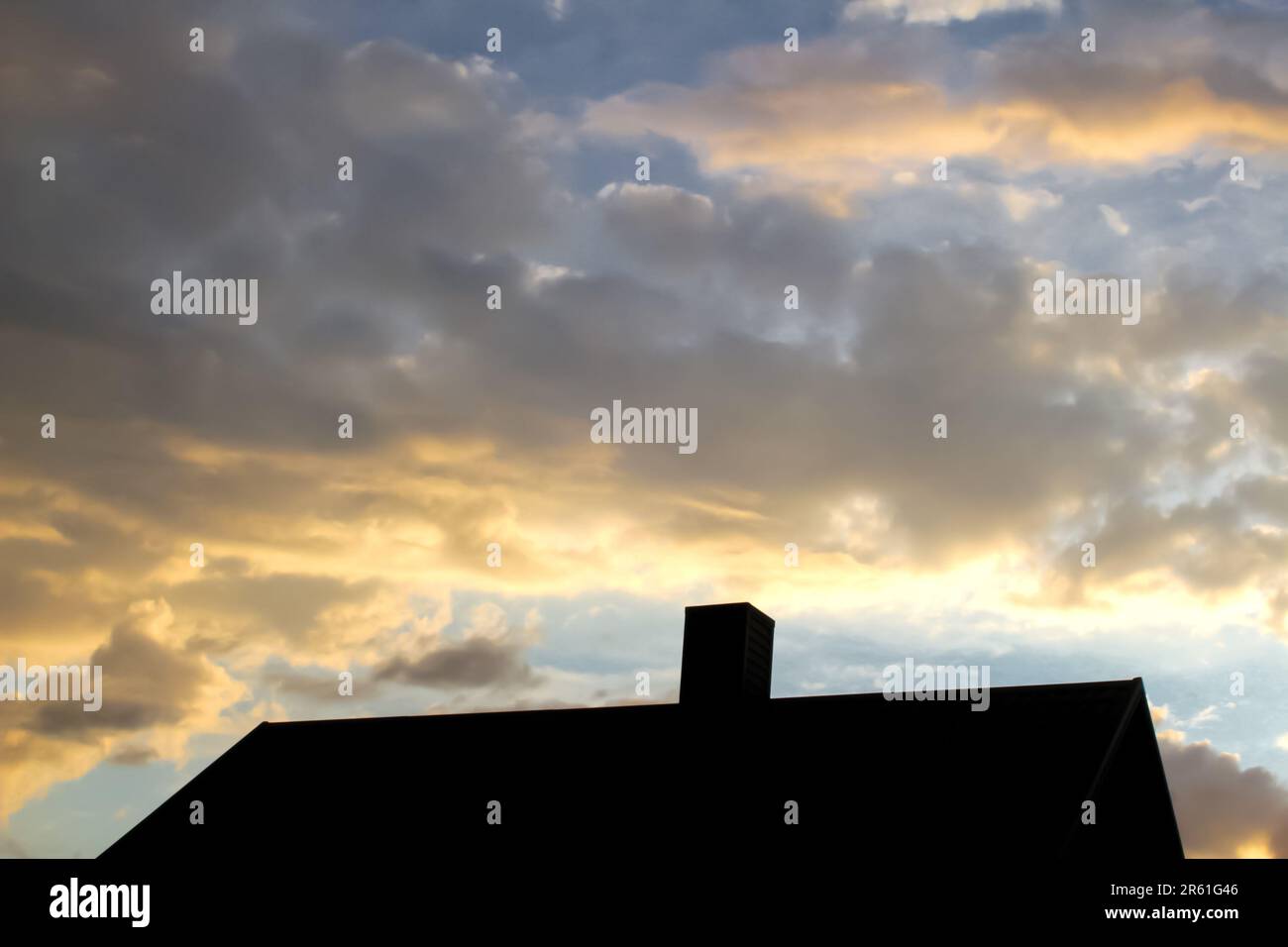 Defocus steel roof on sunset sky background. Dark rain clouds above the