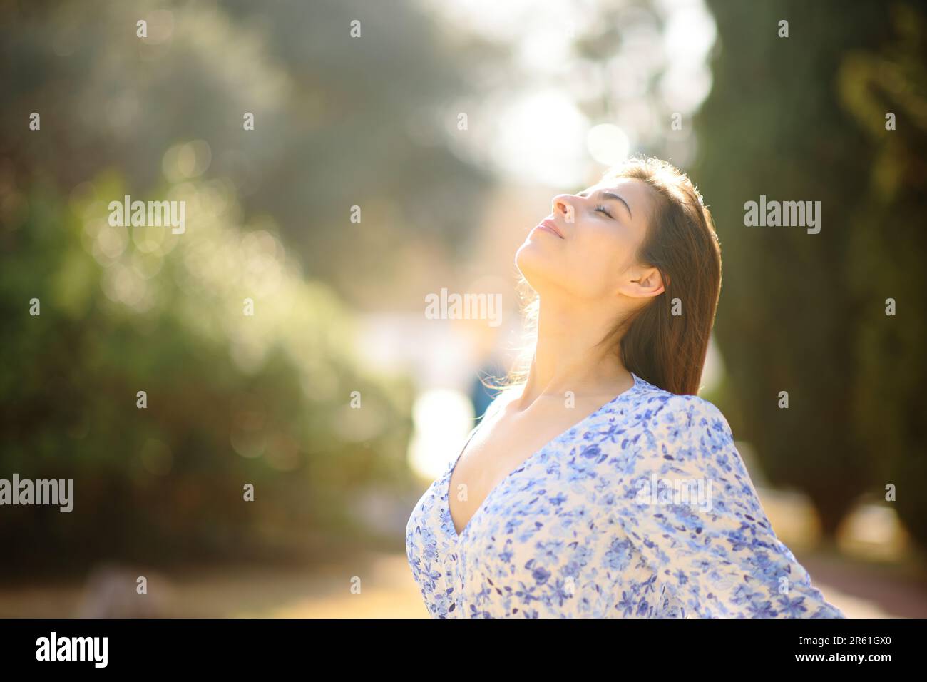 Woman breathing fresh air in a park standing alone Stock Photo - Alamy