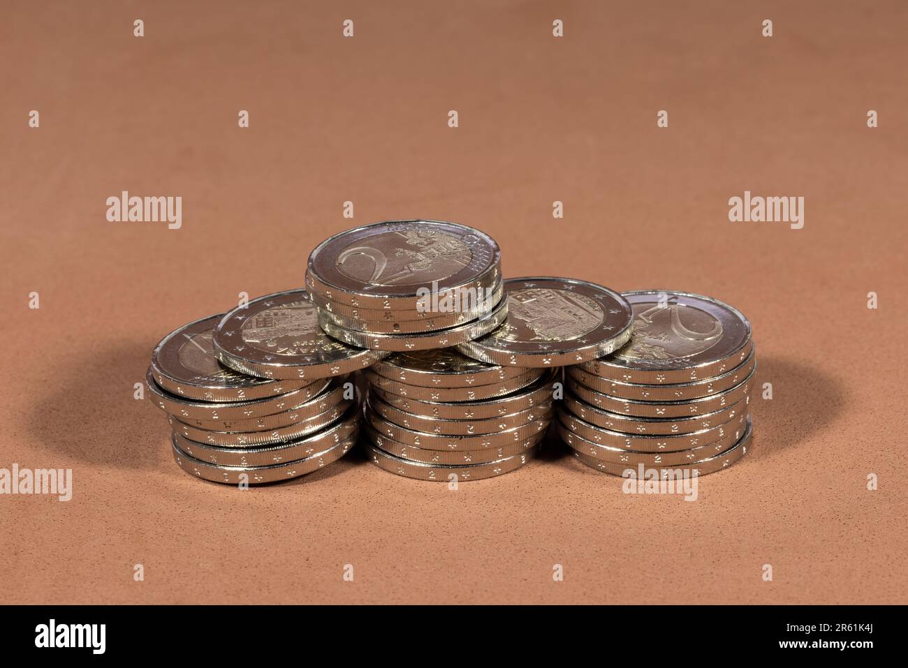 Two euro coins in a neat stack on a brown background Stock Photo - Alamy