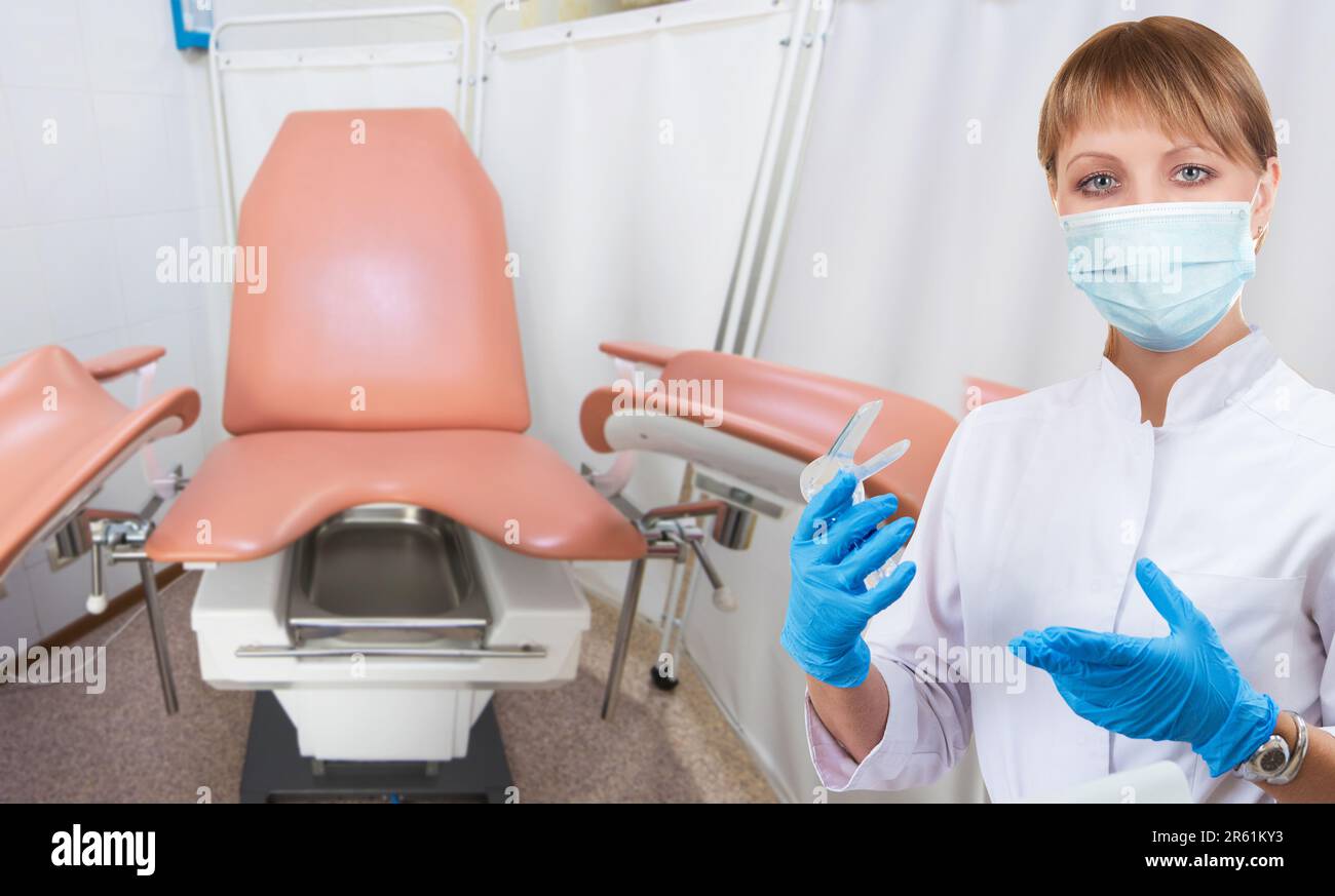 Female gynecologist in protective mask and whitecoat with gynecological