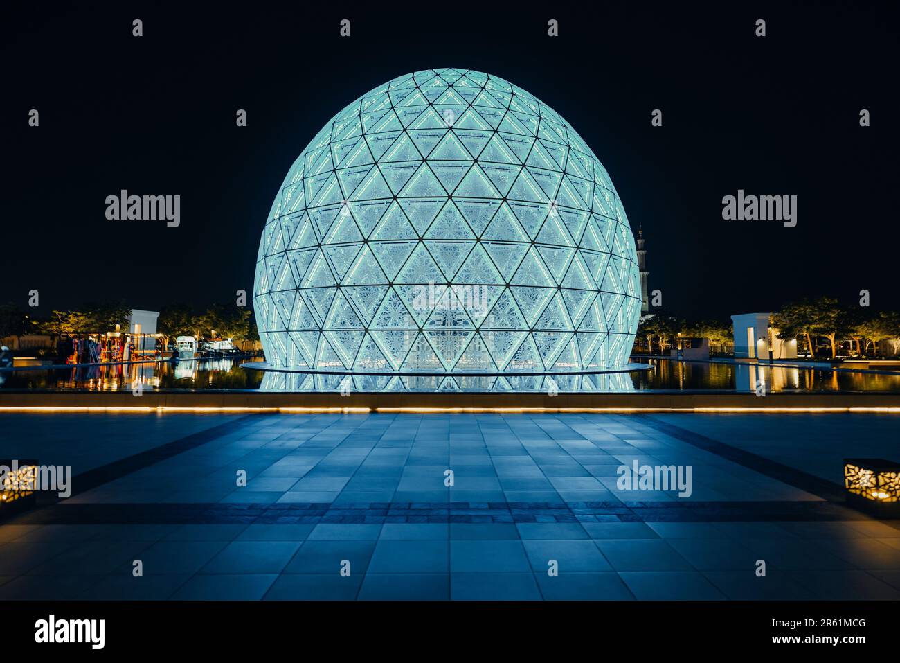 A scenic view of a round modern building illuminated at night in Abu ...