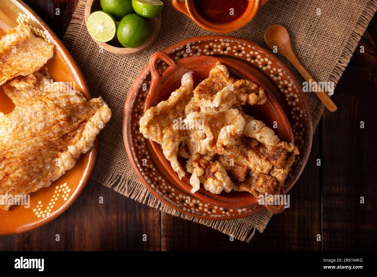 Chicharron. Crispy Fried pork rind, are pieces of aired and fried pork skin, traditional Mexican ingredient or snack served with lime juice and red ho Stock Photo