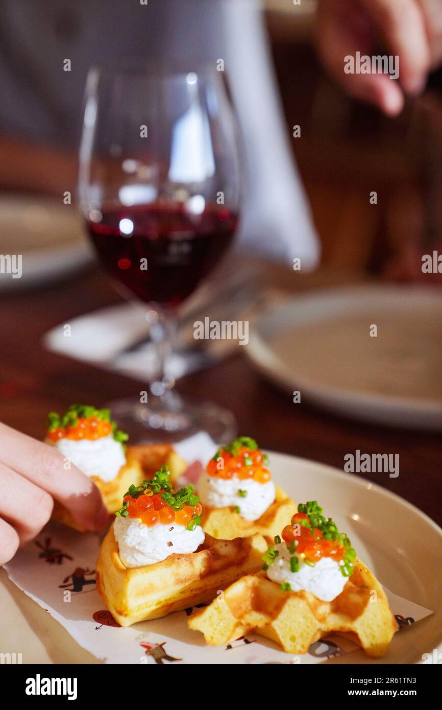 An image of a plate of savory appetizers featuring golden waffles ...