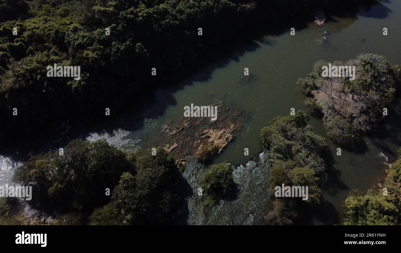An aerial view of a river winding its way through a dark green forest ...