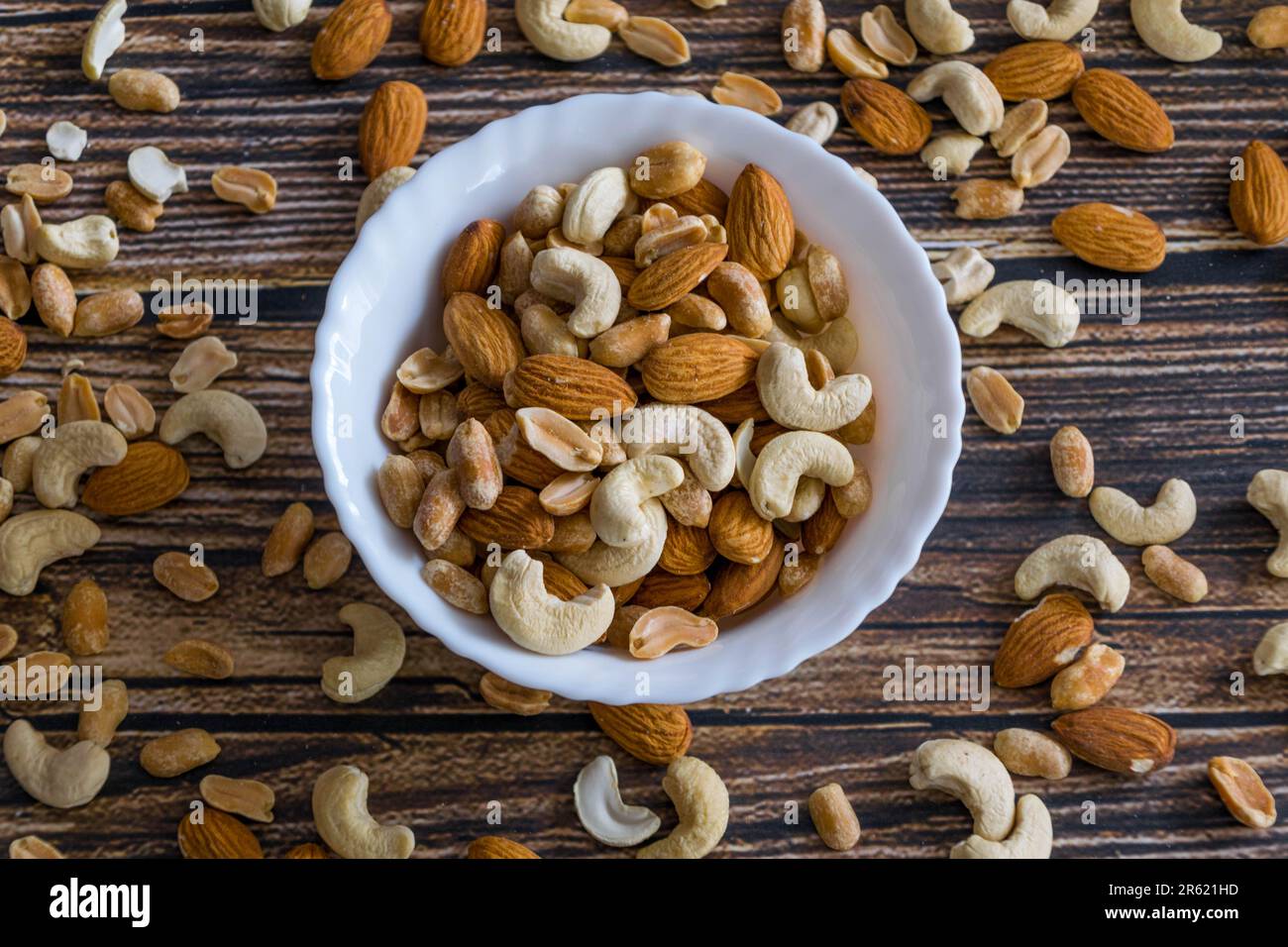 An isolated white ceramic bowl filled with a variety of mixed nuts Stock Photo