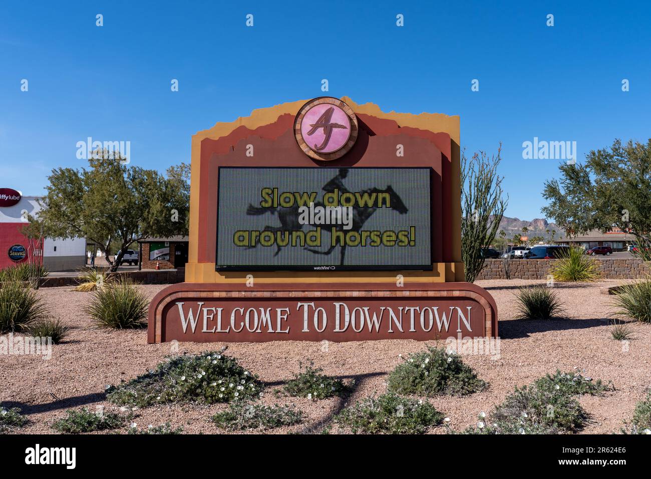 Apache Junction, AZ - March 13, 2023: Electronic sign says Welcome to Downtown and Slow Down around Horses. Stock Photo