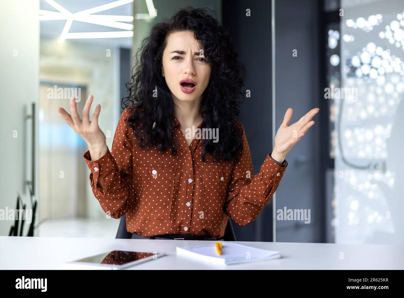 Angry and angry business woman inside office at workplace, latina woman yelling at camera, boss talking displeased with employees remotely online meeting video call. Stock Photo