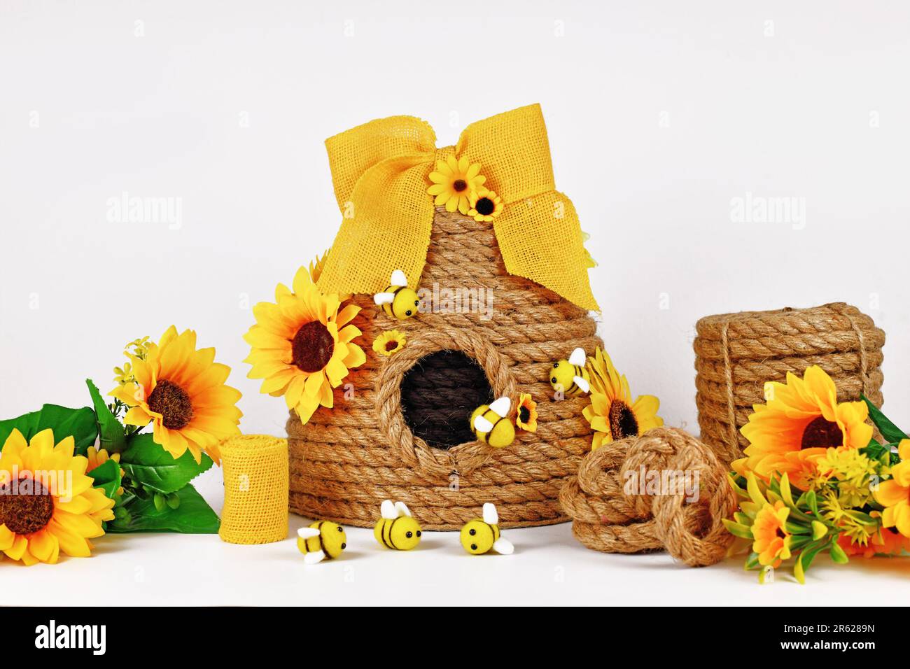 Rope beehive decoration with materials like fake flowers, jute rope and