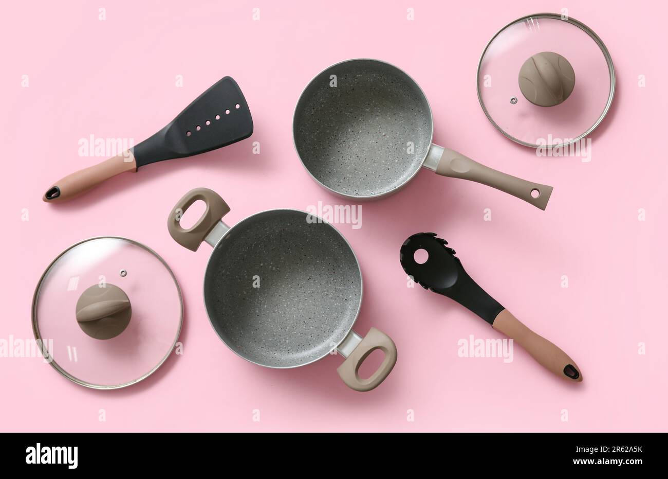 Cooking pots and kitchen utensils on pink background Stock Photo - Alamy