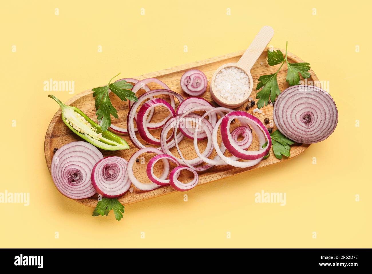 Board with fresh onion slices and spices on yellow background Stock ...