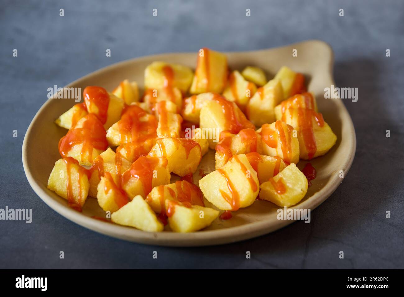 An appetizing image of a bowl containing diced apple pieces and cheese covered in a light layer of sauce Stock Photo