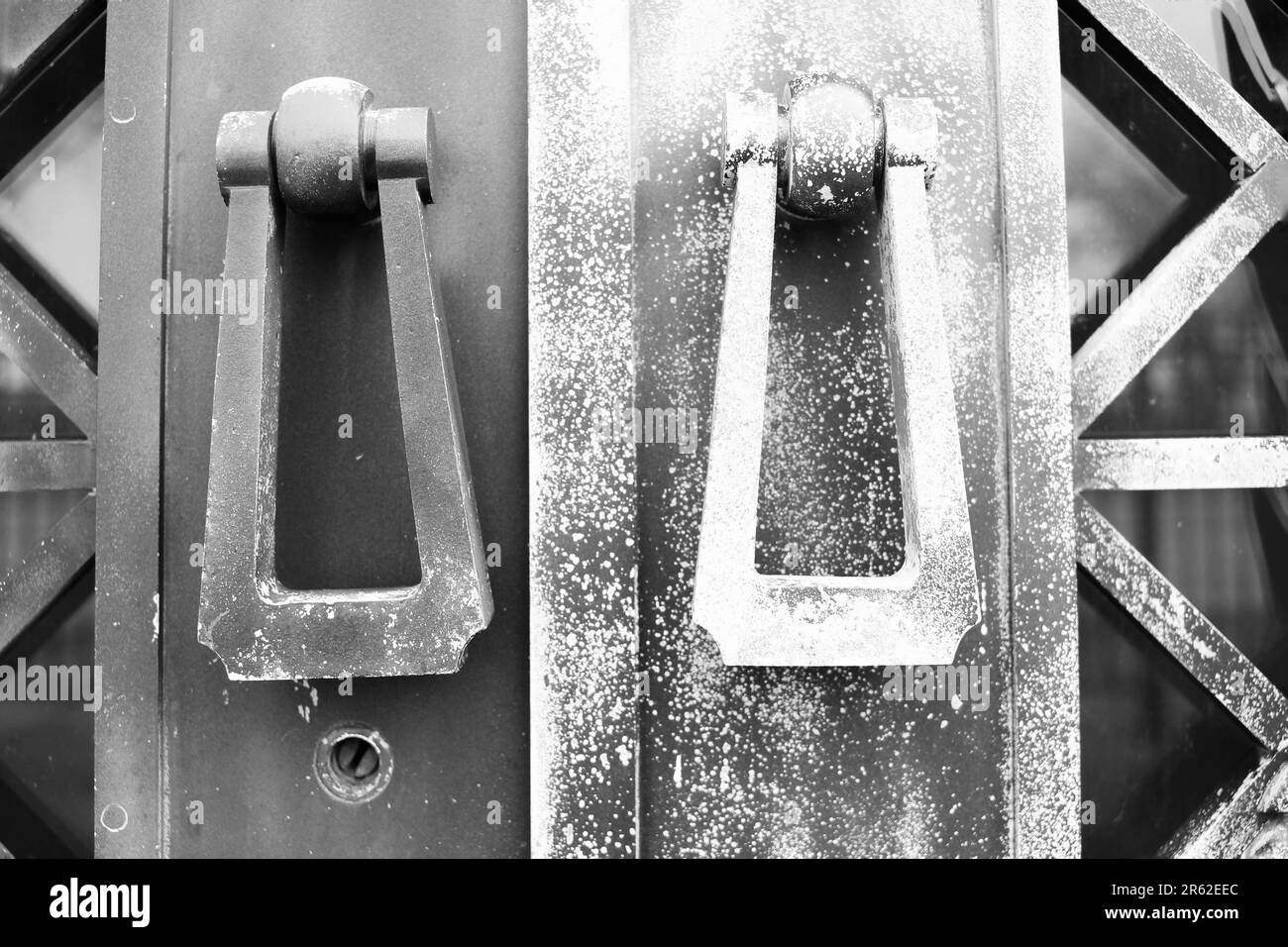 Fancy metal door knockers hanging on a protective medieval gate in a