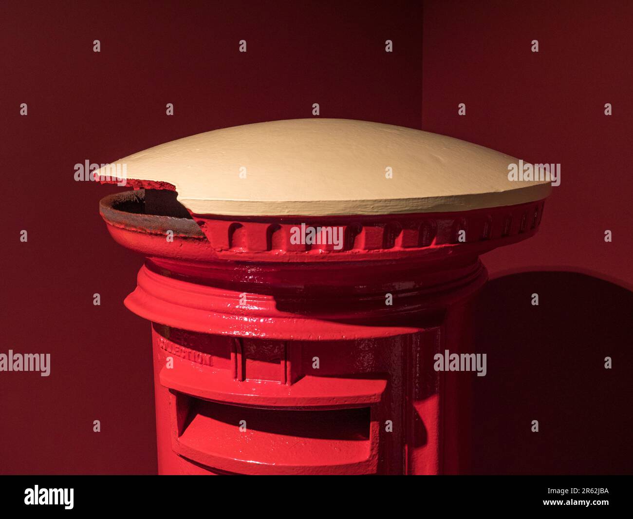 A George V red coloured pillar box (1927-1935) with white top to avoid accidents during WWII blackouts on display in the Postal Museum in London, UK. Stock Photo