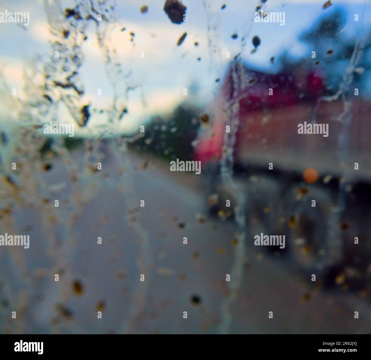 Dirty road after rain. Dirt highway with dirt flies on the windshield