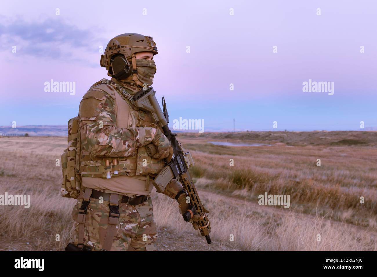 A man wearing a military uniform with a rifle Stock Photo - Alamy