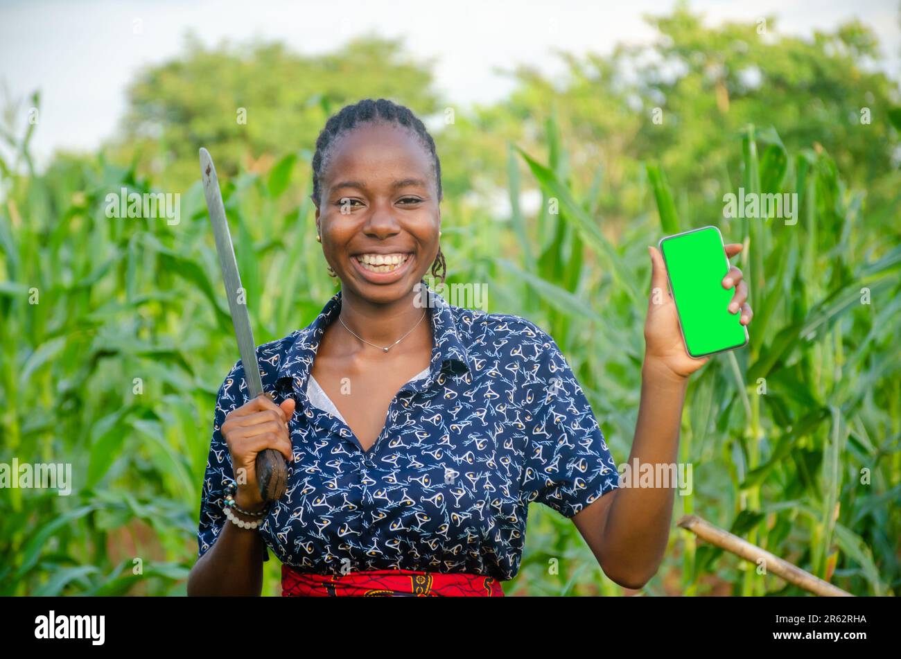 female african farmer using her phone. african farmer checks her mobile phone, texts and chat Stock Photo