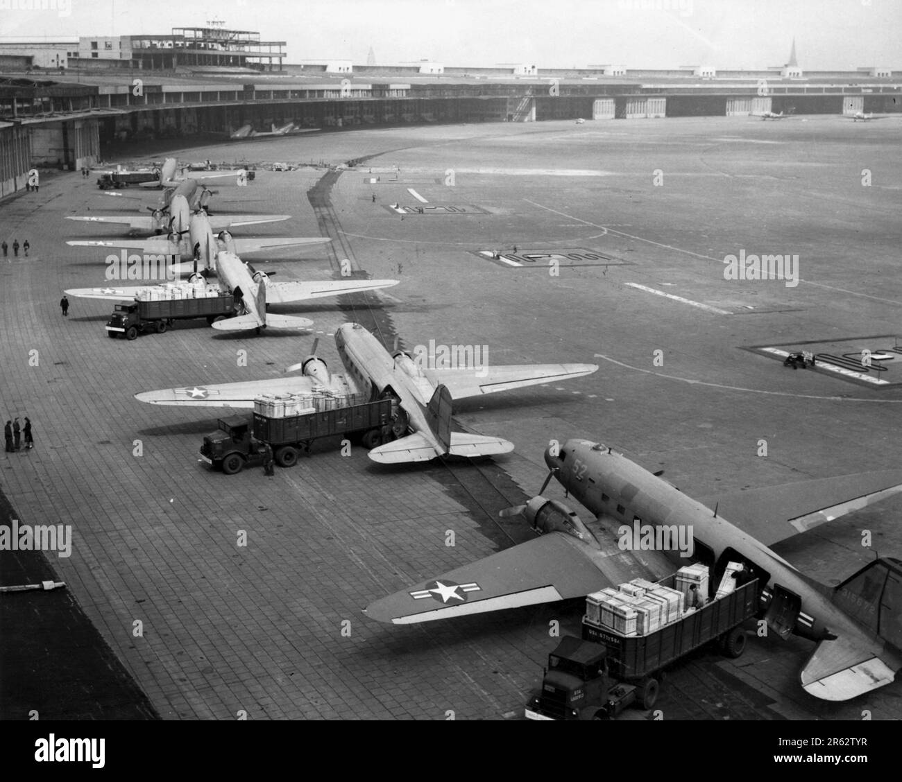 C-47 Skytrains unloading at Tempelhof Airport during the Berlin Airlift. In response escalating tensions and to the establishment of.a new West German currency, the Soviets cut off all land communications to West Berlin and stopped sending food there. TheAllied response was an eleven month campaign to supply W Berlin with the 5000 tons per day of food and fuel it needed. A plane landed every three minutes day and night and the operation was so succesful that the Soviets had to back down and reopen the roads, railways and canals. Stock Photo
