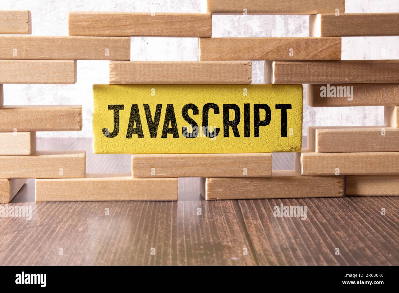 JavaScript programming language. Paper width word JavaScript and laptop, glasses and coffee on wooden table. Stock Photo