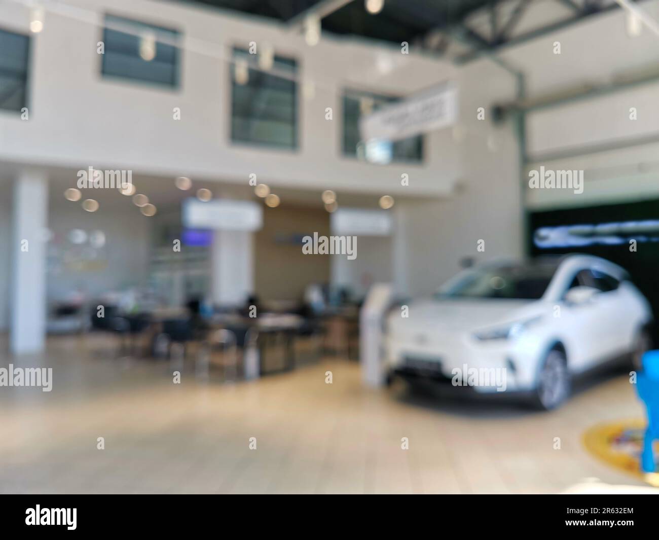 Interior of modern salon with new cars, blurred view. The sun light. Sunlight pours in through the panoramic windows. Stock Photo