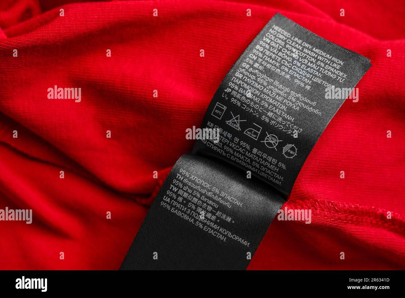 Black clothing labels on red garment, top view Stock Photo - Alamy