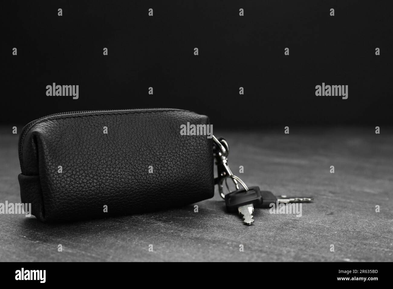 Leather case with keys on grey table, closeup. Space for text Stock Photo