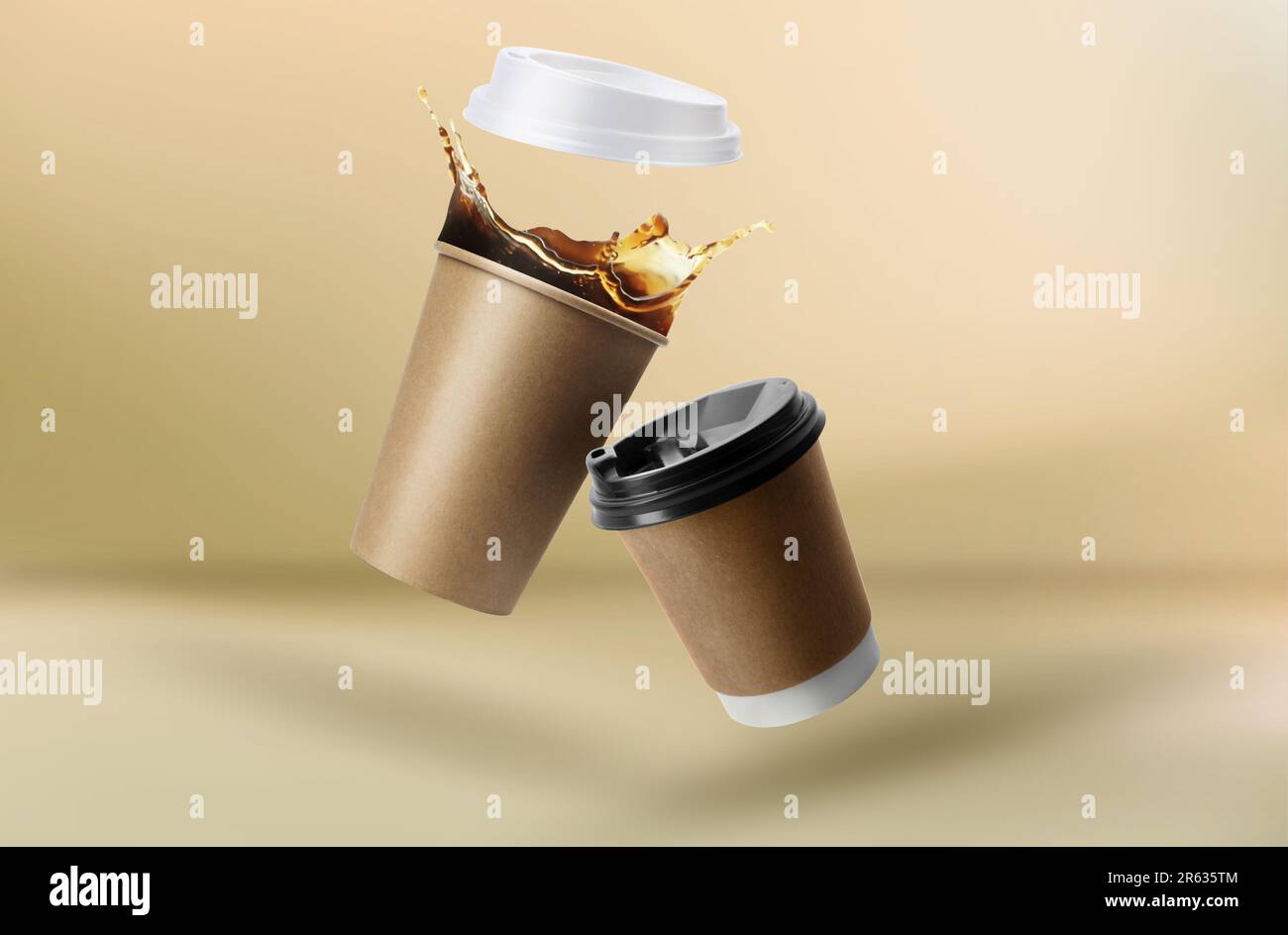 Takeaway paper cups falling on beige background Stock Photo - Alamy