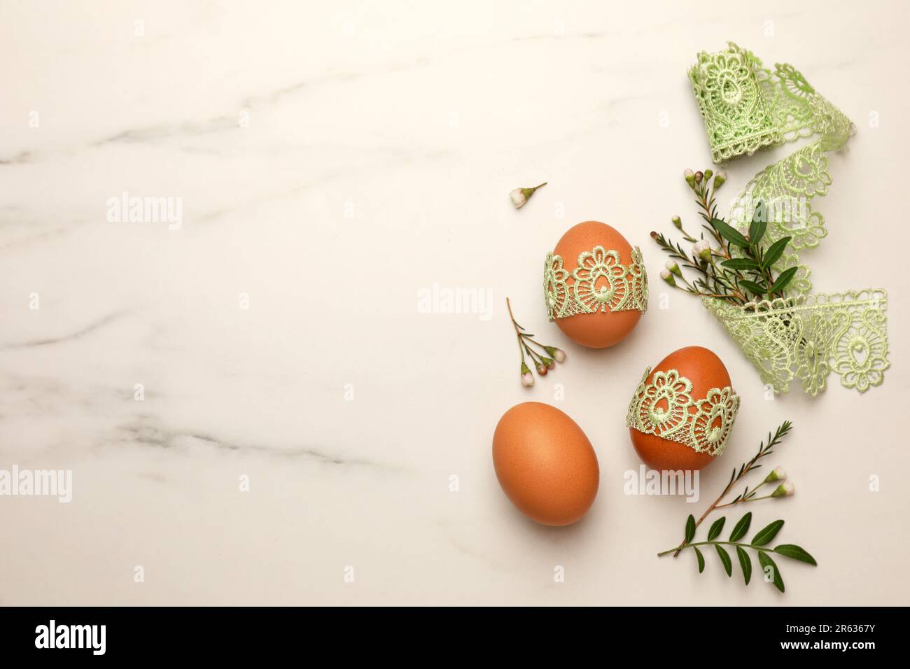 Flat lay composition with Easter eggs, twigs and lace ribbon on white ...