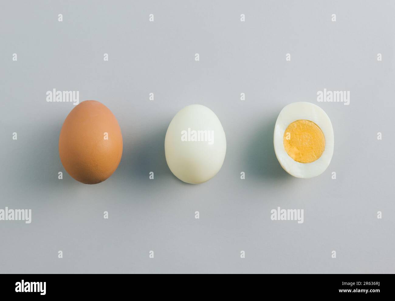 Whole chicken egg, egg without eggshell and cracked half in the middle