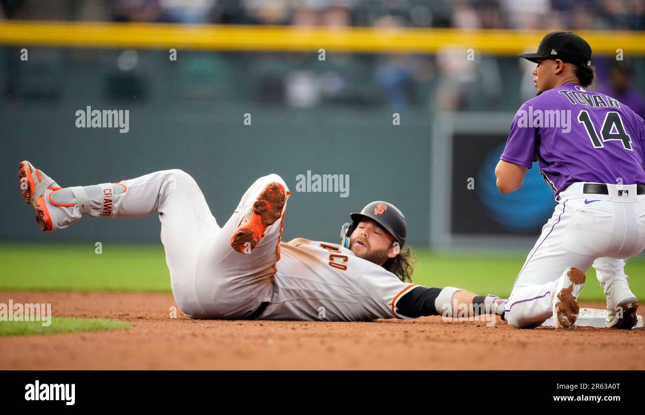 San Francisco Giants' Brandon Crawford, left, avoids the tag from Colorado  Rockies shortstop Ezequiel Tovar as Crawford slides into second base with  an RBI-double in the second inning of a baseball game
