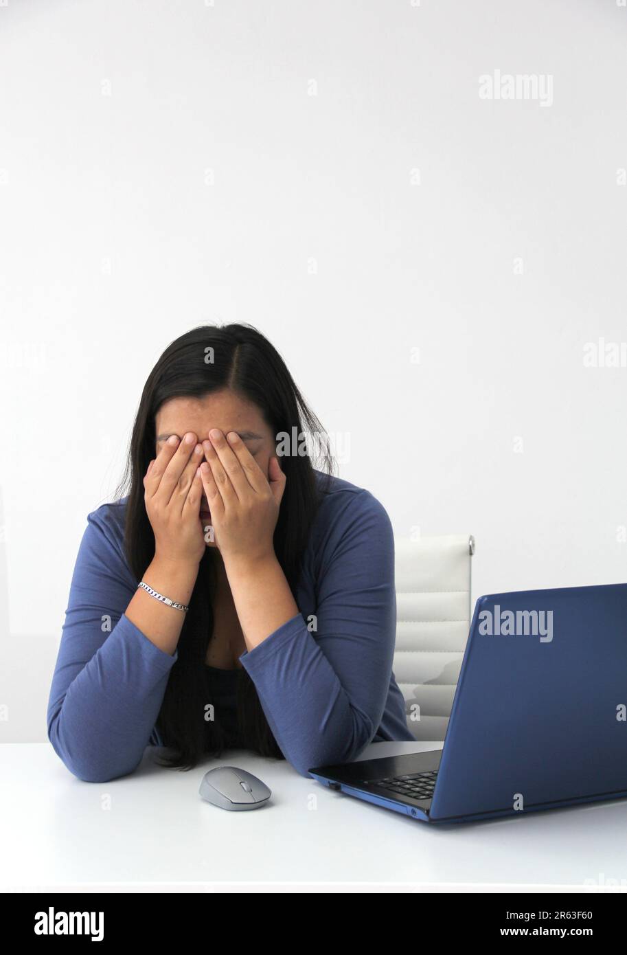 Dark-haired latin adult woman works in her office with laptop with a ...