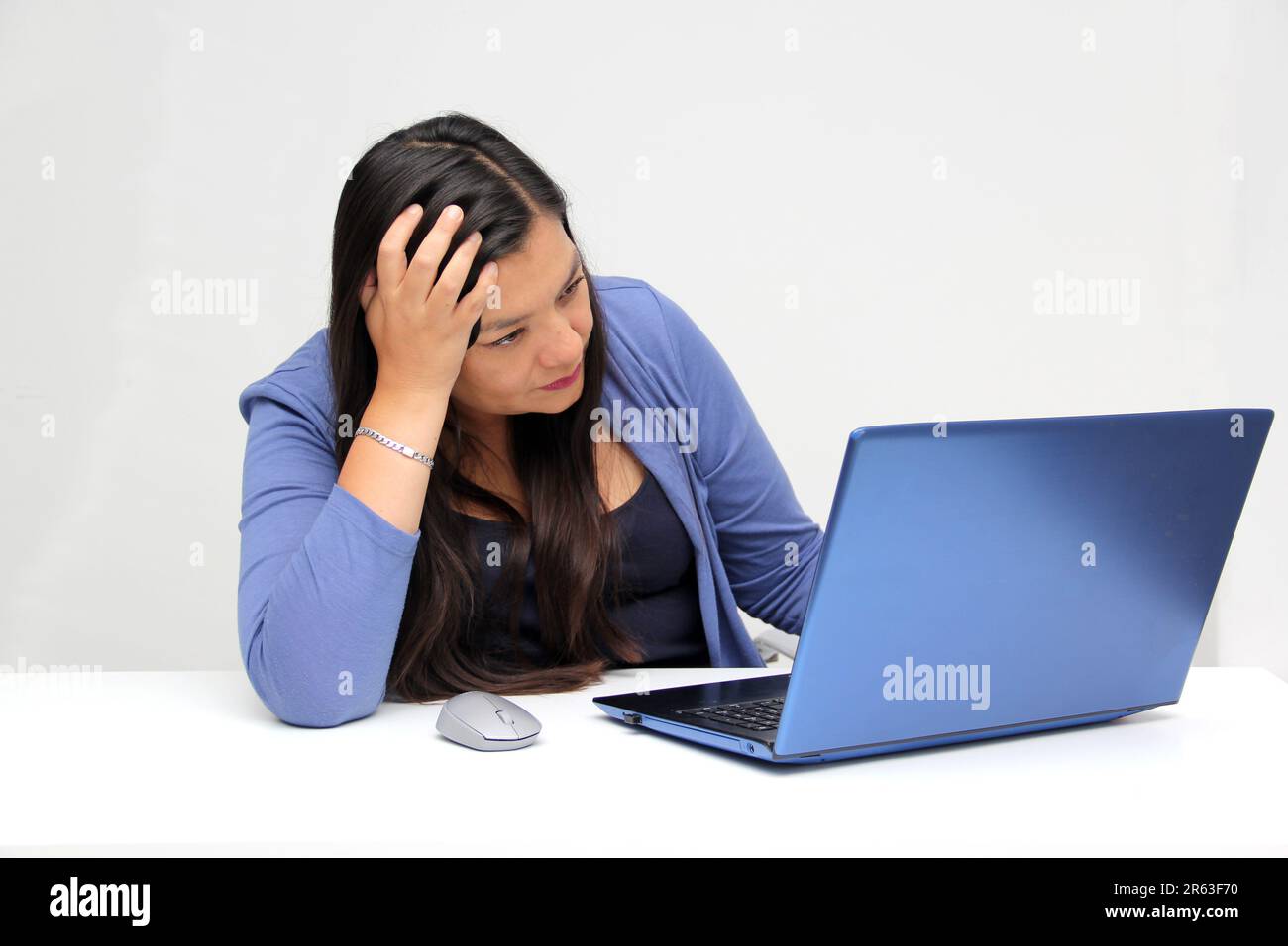 Dark-haired latin adult woman works in her office with laptop with a ...