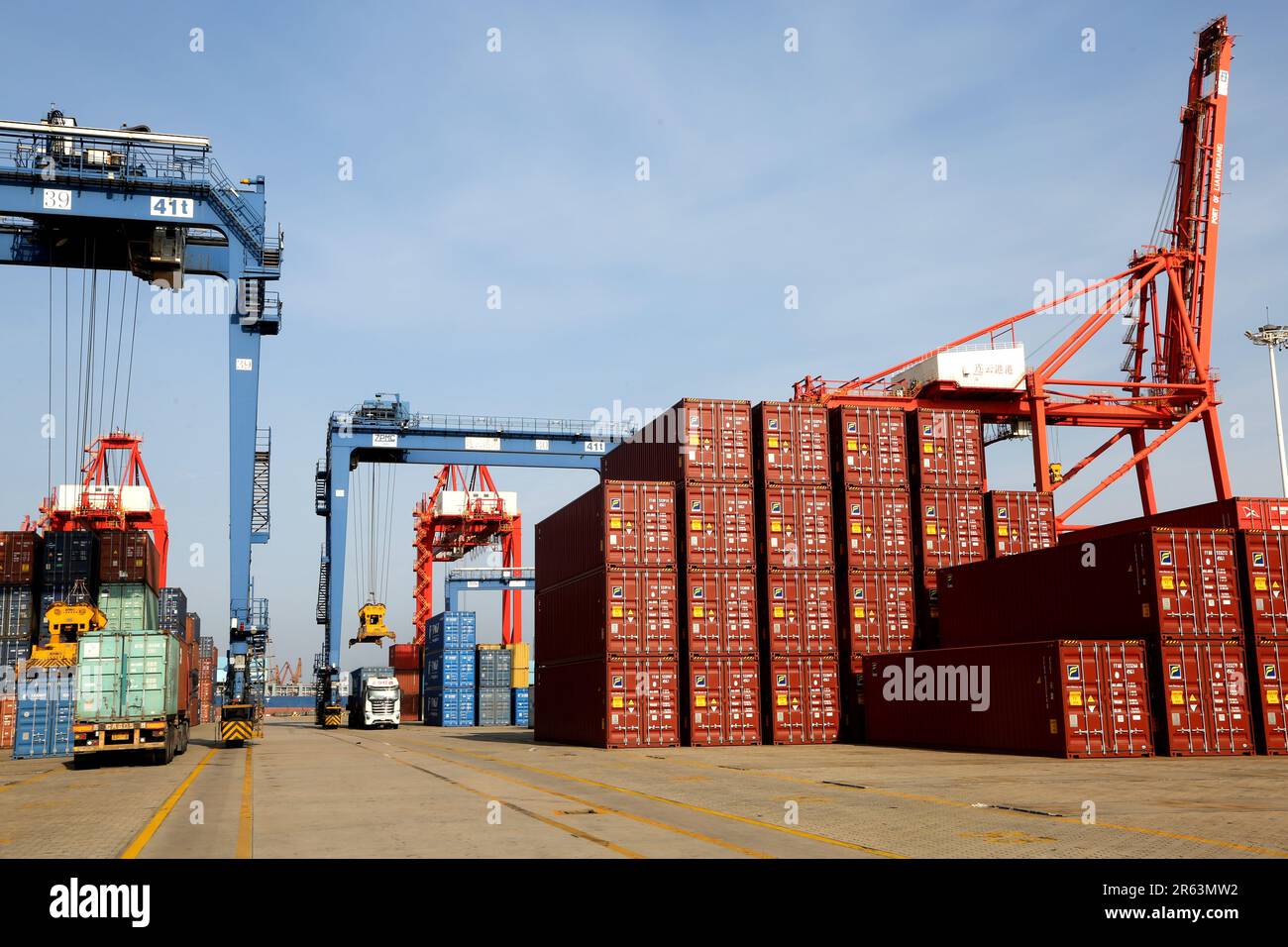 LIANYUNGANG, CHINA - JUNE 7, 2023 - A transport vehicle delivers containers to a cargo ship at the container terminal in Lianyungang Port, east China' Stock Photo